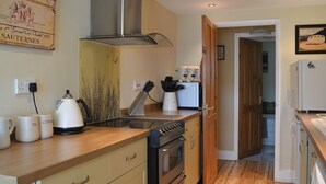 Eine Küche mit Holzausstattung, einem Edelstahl-Kochfeldabzug, einer Kaffeemaschine und einem Toaster.