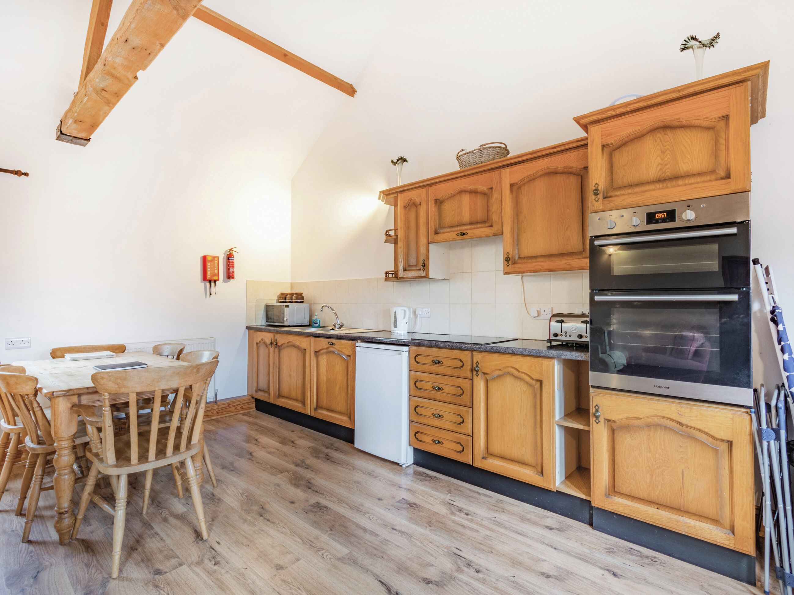 A kitchen with wooden cabinets, a microwave, a toaster, and a dishwasher.