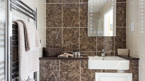 A bathroom with a mirror, sink, and towel rack. - 1 bedroom accommodation in South Elkington, near Louth (South Elkington, near Louth)