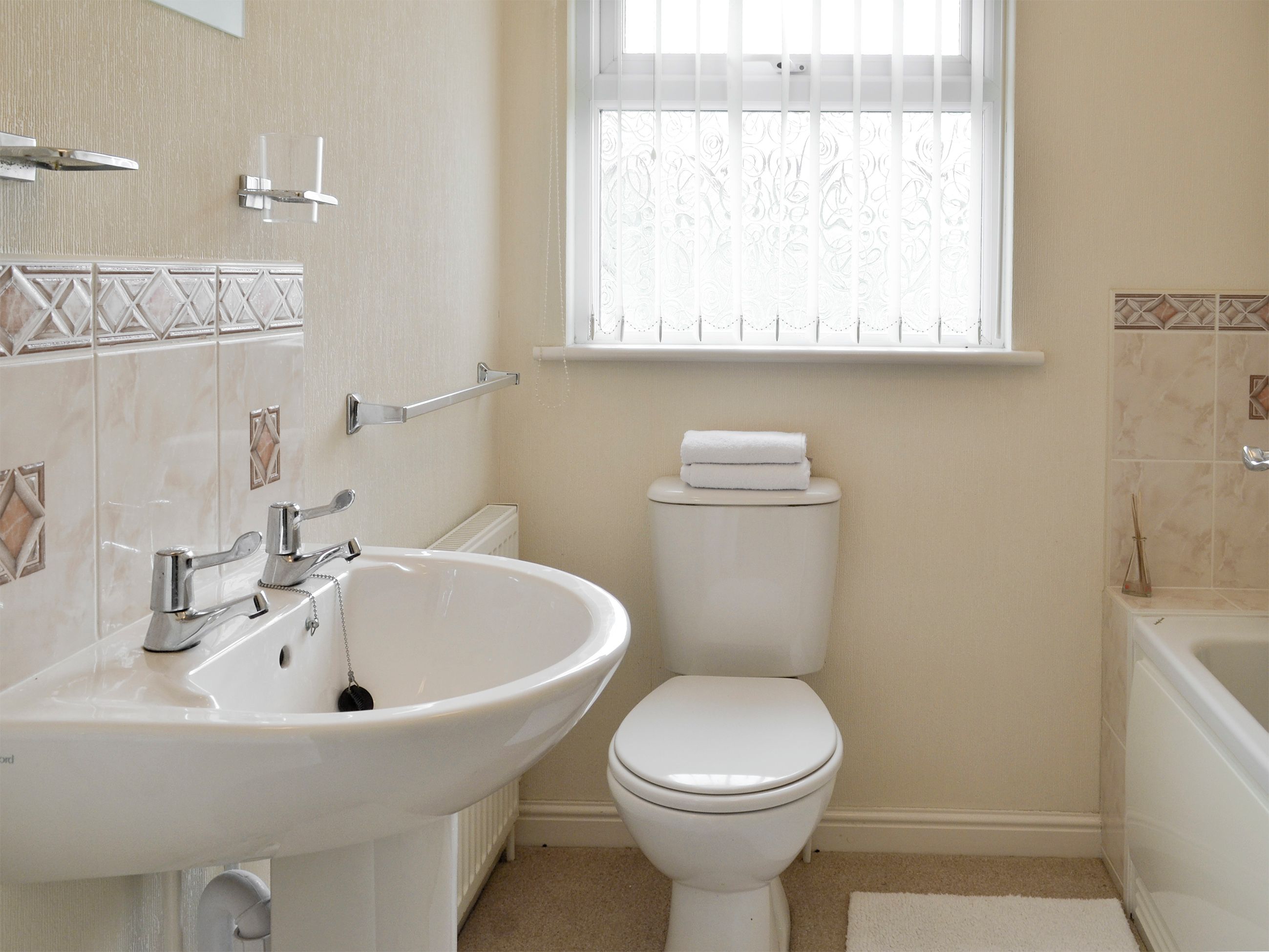 A bathroom with a white sink, toilet, and bathtub.