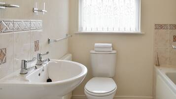 A bathroom with a white sink, toilet, and bathtub.