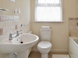 A bathroom with a white sink, toilet, and bathtub.