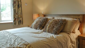 Una cama bien hecha con un edredón estampado con motivos de cebra y dos almohadones decorativos.