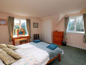 A bedroom with a bed, a dresser, a chair, a desk with a mirror, and two windows with curtains. - 4 bedroom accommodation in Gatehouse of Fleet, Kirkcudbright (Gatehouse of Fleet, Kirkcudbright)