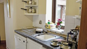 Una cocina con lavavajillas, un lavabo y una ventana con vistas al exterior.
