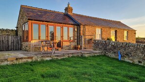 A stone house with a tiled roof, large windows, and a stone wall. - 1 bedroom accommodation in Baldersdale, near Barnard Castle (Baldersdale, near Barnard Castle)