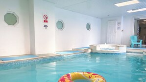 An indoor swimming pool with a floating ring, tiled walls, and a door leading to another room. - 2 bedroom accommodation in Pyworthy, near Holsworthy (Pyworthy, near Holsworthy)