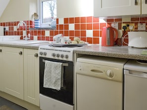 A kitchen with a stove, oven, dishwasher, and a window above the sink. - 2 bedroom accommodation in Pyworthy, near Holsworthy (Pyworthy, near Holsworthy)