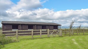 A stable with open stalls and a wooden fence. - 1 bedroom accommodation in Hapton (Hapton)