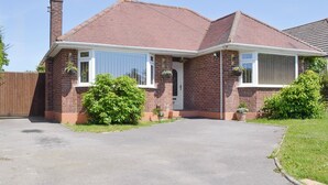 A two-story brick house with a tiled roof, a front porch, and a driveway. - 1 bedroom accommodation in Broadstone, near Bournemouth (Broadstone, near Bournemouth)