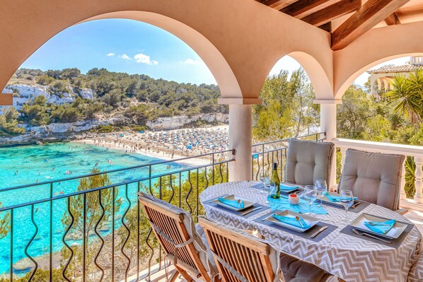 An outdoor dining area with a view of a beach and cliffs.