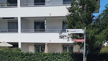 Ein mehrgeschossiges Gebäude mit Balkonen, einem Schild mit der Aufschrift 'maselliLOFT' und einem Straßenschild für 'V. Sandgasse'.
