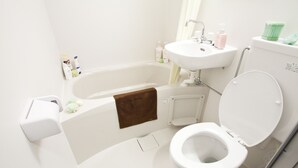 A modern bathroom with a white bathtub, sink, and toilet. - Nagomi House (Tokyo)