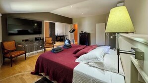 Ein Hotelzimmer mit Bett, Schreibtisch, Stuhl und Fernseher.