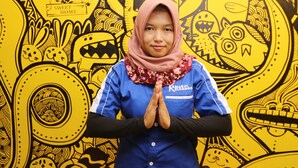 A person standing in front of a vibrant yellow wall with various black illustrations. - Kamar Keluarga Mangga Besar (Jakarta)
