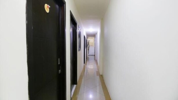A narrow hallway with doors on one side and a staircase at the end. - Kamar Keluarga Mangga Besar (Jakarta)