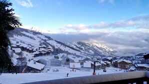 A snow-covered mountain village with traditional wooden buildings, a ski lift, and a clear sky. - Le Portail 13 - Outstanding apartment at the foot of the slopes (LES AVANCHERS VALMOREL)