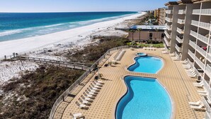 A resort with a pool area, beach access, and a view of the ocean.