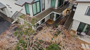A modern two-story house with a balcony, a small garden, and a visible staircase. - Cute one bedroom condo. walk to the beach and st Armand circle (Sarasota)