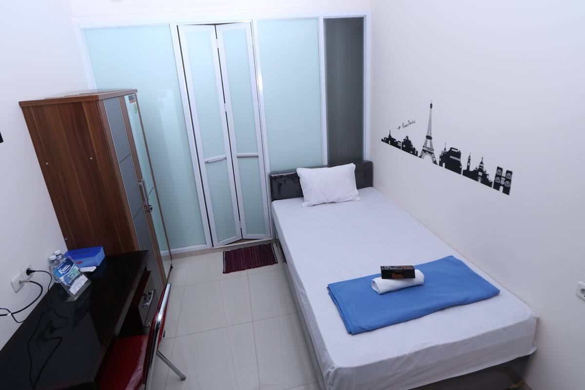 Une chambre d’hôtel comprenant un lit, un bureau, une armoire et un élément décoratif mural.