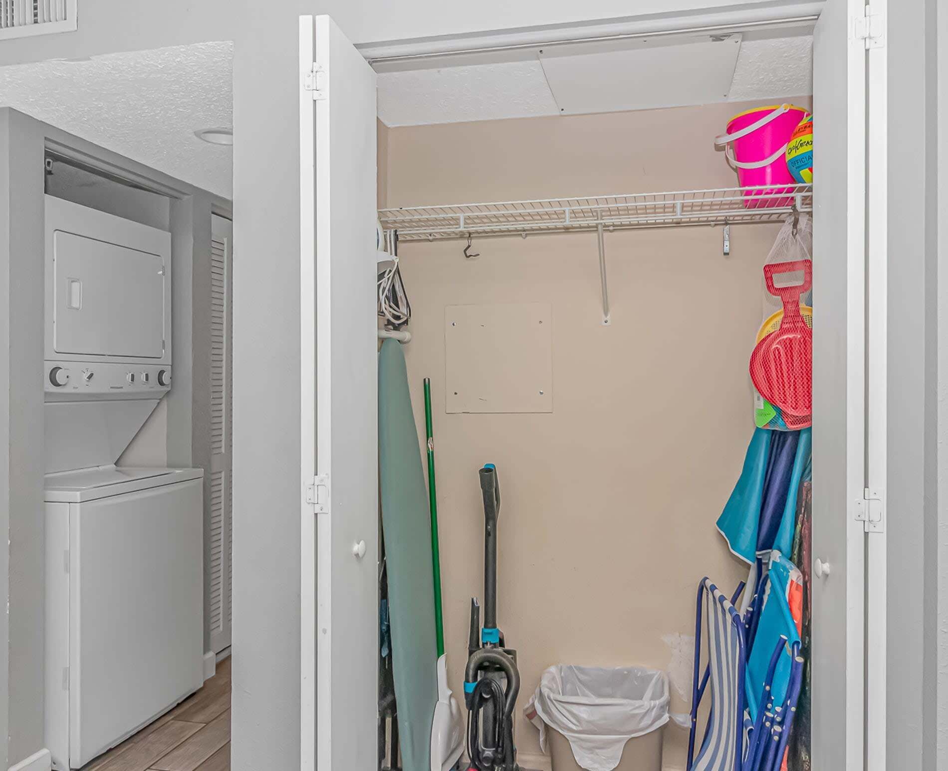 A laundry room with a washing machine, dryer, and a clothes drying rack.