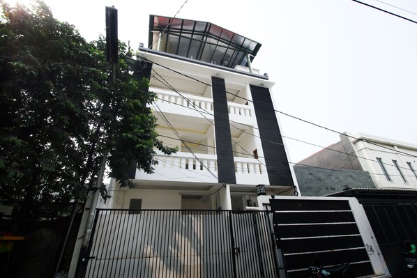 Un edificio de varios pisos con un balcón en el nivel superior.
