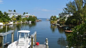 Un port de plaisance avec des bateaux amarrés, un ciel dégagé et des immeubles résidentiels le long de la côte.
