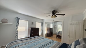 Um quarto com cama, penteadeira e guarda-roupa.
