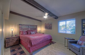 A bedroom with a large bed, a nightstand, a reading lamp, a window with blinds, and a ceiling fan. - STARFIRE Golf VIEW, Pvt POOL w/opt Heat, Putting Green, Fire Pit, 10 mins to Old Town (Scottsdale)