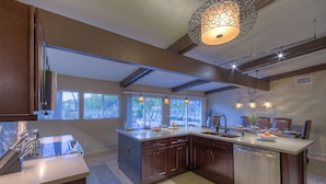 A spacious kitchen with a large island, wooden cabinets, and pendant lighting. - STARFIRE Golf VIEW, Pvt POOL w/opt Heat, Putting Green, Fire Pit, 10 mins to Old Town (Scottsdale)
