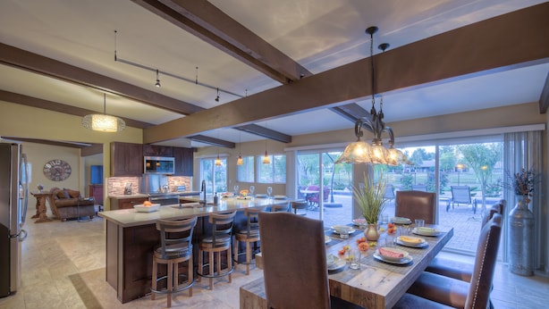 A spacious kitchen with a large island, bar stools, and a dining area with a long table and chairs. - STARFIRE Golf VIEW, Pvt POOL w/opt Heat, Putting Green, Fire Pit, 10 mins to Old Town (Scottsdale)