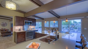 A spacious kitchen with a large island, wooden cabinets, and pendant lighting. - STARFIRE Golf VIEW, Pvt POOL w/opt Heat, Putting Green, Fire Pit, 10 mins to Old Town (Scottsdale)