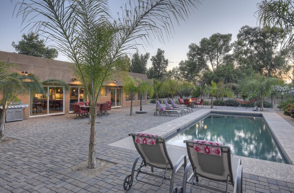 A poolside area with lounge chairs, a small pool, and a building with a glass door entrance. - STARFIRE Golf VIEW, Pvt POOL w/opt Heat, Putting Green, Fire Pit, 10 mins to Old Town (Scottsdale)
