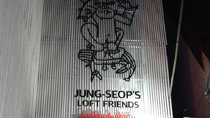 A building with a sign reading "JUNG-SEOP'S LOFT FRIENDS" and a neon sign below. - Friends of Loft - Hostel (Tongyeong)