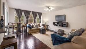 A living room with a sofa, a coffee table, a TV, and a ceiling fan. - Minutes to it all! Restaurants, Parks, Trails. Pet's Ok (Austin)