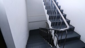 Una escala amb baranes metàl·liques i graons foscos.