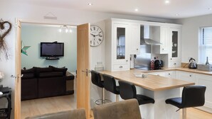 A modern kitchen with white cabinets, a built-in oven, and a coffee machine. - 2 bedroom accommodation in Alnwick (Alnwick)