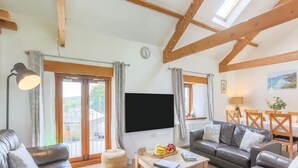 Ein modernes Wohnzimmer mit Sofa, Couchtisch und Fernseher.