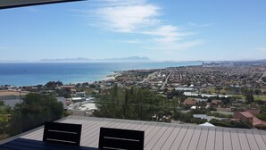 A coastal town with a view of the sea and mountains in the distance. - Private Villa With Magnificent Sea Views  (Cape Town)