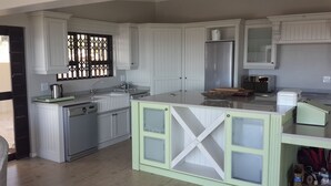 A modern kitchen with white cabinetry, a stainless steel refrigerator, and a dishwasher. - Private Villa With Magnificent Sea Views  (Cape Town)