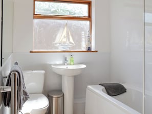 A bathroom with a toilet, sink, and bathtub.