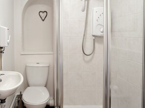 A bathroom with a toilet, a sink, and a shower enclosure. - St Martins Square Apartment 2 (Scarborough)