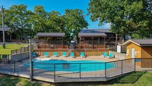 A swimming pool with a wooden deck and lounge chairs, surrounded by a fence. - Guests say amazing views, 2 miles to SDC (Reeds)