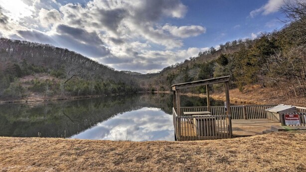 A wooden dock extending into a calm lake, surrounded by forested hills and a clear sky. - Guests say amazing views, 2 miles to SDC (Reeds)