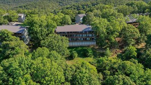A multi-story hotel surrounded by dense forest, with a clear view of the surrounding landscape. - Guests say amazing views, 2 miles to SDC (Reeds)