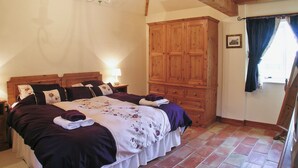 A bedroom with a large bed, wooden wardrobe, and a chandelier. - 3 bedroom accommodation in Brigham (Brigham)