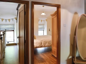 Une chambre à coucher avec un lit, une armoire en bois et un miroir.