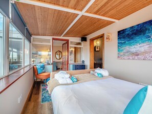 A bedroom with a wooden ceiling, a large bed, a desk, a chair, a window, and a painting. - 1 bedroom accommodation in Bargrennan, near Glentrool (Bargrennan, near Glentrool)