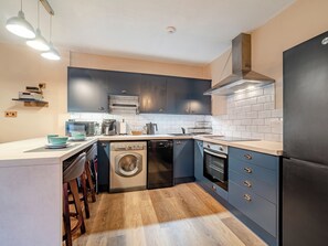 A modern kitchen with built-in appliances, a dishwasher, oven, and a microwave.