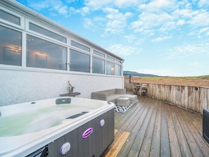 A hot tub on a wooden deck with a view of the landscape. - 1 bedroom accommodation in Bargrennan, near Glentrool (Bargrennan, near Glentrool)
